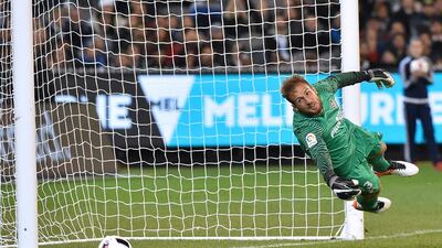 Atletico’s keeper Jan Oblak dives to make a save during the International Champions Cup football match between English Premier League team Tottenham Hotspur and Spanish club Atletico Madrid in Melbourne on July 29, 2016. / AFP / Paul Crock