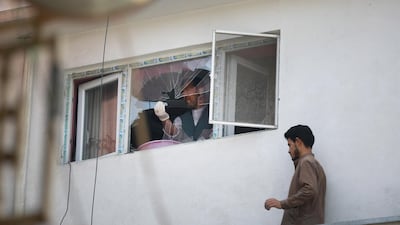 A man removes broken glass after a rocket hit the roof of his house, in Kabul, Afghanistan. EPA