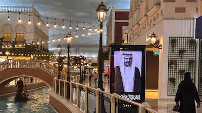 A gondola passes a portrait of Qatar's former emir Sheikh Hamad bin Khalifa at a mall in Doha after the announcement of his death. AFP