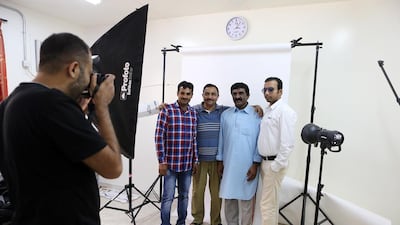 Mohamed Somji from Gulf Photo Plus Gallery takes the photo of, from left, Khan Murli Basher, Jawed Khan, Shabbir Hussain and Manawwar Khan at Al Quoz Industrial Area in Dubai. Pawan Singh / The National