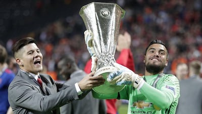 Sergio Romero, right, lifts the Europa League trophy with injured Manchester United defender Marcos Rojo. Michael Sohn / AP Photo