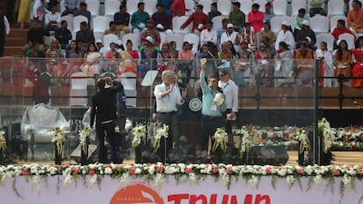 An officer directs workers to clean the glass enclosure erected on the podium where U.S. President Donald Trump and Indian Prime Minister Narendra Modi will be seated at Sardar Patel stadium in Ahmedabad, India. AP Photo