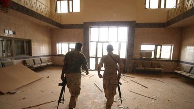 Iraqi pro-government forces exit a building in the Officers neighbourhood of Fallujah after checking it for ISIL militants.