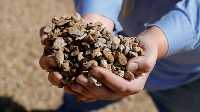 A worker holds crushed ore at the MP Materials rare-earth mine in Mountain Pass, California. Reuters
