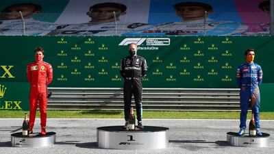 Valtteri Bottas stands on the top step of the podium alongside runner-up Charles Leclerc of Ferrari, left, and third placed McLaren's Lando Norris.