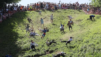 Competitors take a tumble during the annual Cooper's Hill cheese rolling competition in Gloucester. AFP