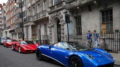 LONDON, ENGLAND - JULY 23: Ferraris are pictured behind a blue Dubai-registered Pagani Huayra on July 23, 2015 in London, England. London has become known in recent years for a proliferation of foreign cars worth hundreds of thousands of pounds with tourists and car spotters stopping to admire the vehicles. (Photo by Carl Court/Getty Images)