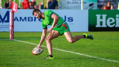 Jebel Ali Dragons (Green) v Dubai Frogs (blue): Ian Overton of the Jebel Ali Dragons scores during Day 1 of the Emirates Airlines Dubai Rugby Sevens at The Sevens in Dubai on Thursday. Victor Besa for The National