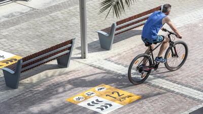 Signs warn cyclists and e-scooter riders they cannot exceed 12kph on Marina Walk. Antonie Robertson / The National