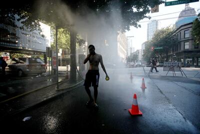 A resident walks through a temporary misting station on Abbott Street during a heatwave in Vancouver, British Columbia, Canada, on June 28. The heat is expected to continue for several days in some parts of British Columbia, according to weather warnings from the government. Photographer: Trevor Hagan / Bloomberg
