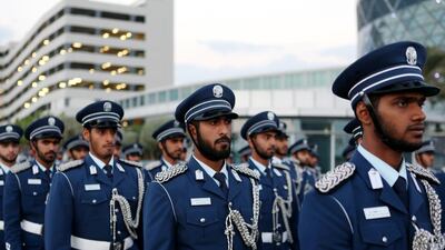 Police officers wait for their bus after doing their part in the parade.