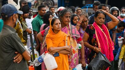 People queue up to buy kerosene for domestic use at a supply station in Colombo on Tuesday. AFP