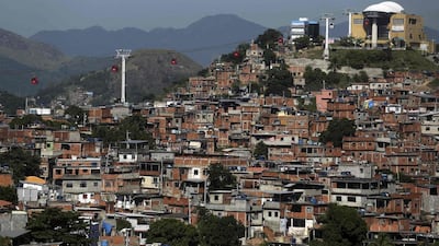 Cable cars are seen over the Complexo do Alemao slum in Rio de Janeiro. After a half-century of neglect, it seemed the government finally cared about Rio’s notorious slums, or favelas, with the implementation of an effort to reclaim huge swaths of the city from criminals. (Pilar Olivares / Reuters / March 30, 2014)