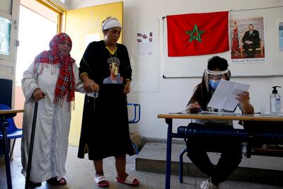 A Moroccan woman guides her mother Zoubida Abaouch to cast her ballot inside a polling station in Casablanca, Morocco on Wednesday.