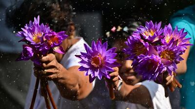 Buddhist devotees hold lotus flowers before offering prayers on the occasion of 'Poya' a religious festival to mark the full moon, at the Kelaniya Buddhist temple in Kelaniya. AFP
