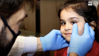 Sama has her glass eye fitted by a medic. Wam