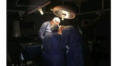 The doctors operate on an injured child during a power cut.