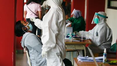 A healthcare worker takes a swab sample to test for Covid-19, during mass testing at a school in Jakarta, Indonesia.