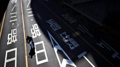 A person rides a moped through an empty street in Tokyo on the National Foundation Day holiday. Eugene Hoshiko / AP Photo