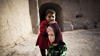 An Afghan girl holds a mannequin as she looks on in the old part of the northwestern city of Herat. Behrouz Mehri / AFP