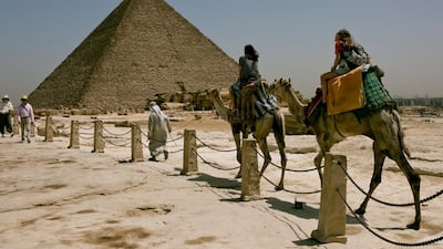 Tourists ride camels during a visit to the Giza Pyramids, near Cairo, Egypt two days after a tour bus struck an improvised explosive device near the site, wounding more than a dozen foreign tourists. AP Photo