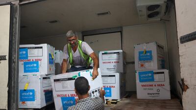 Workers unload a shipment of polio vaccines at a Health Ministry depot in Gaza on Sunday. AFP