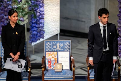 Narges Mohammadi's children, Kiana, left, and Ali Rahmani, stand next to an empty chair with the peace prize diploma for their mother during the awarding of the Nobel Peace Prize for 2023 in Oslo, Norway. EPA