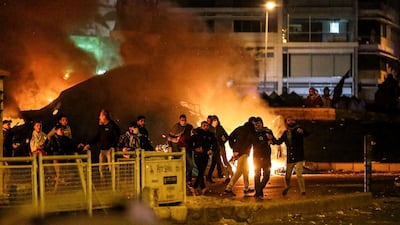 Protesters throw stones at riot police, next burning tents during clashes in central Beirut. EPA
