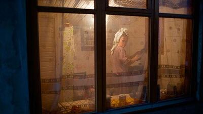 In this photo taken on Wednesday, Nov. 27, 2013, a woman washes up dishes in her kitchen in the yard of a house in the village of Vesyoloye, outside Sochi, Russia. As the Winter Games are getting closer, many Sochi residents are complaining that their living conditions only got worse and that authorities are deaf to their grievances.(AP Photo/Alexander Zemlianichenko)