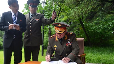 Mr Shoigu signs a guest book during a visit to Mangyongdae. Reuters