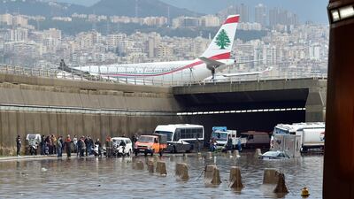 A Middle East Airlines (MEA) plane lands at the airport as vehicles are submerged in water after a heavy downpour on the main road near Rafic Hariri International Airport at the southern entrance of Beirut. EPA