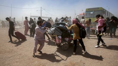 Afghan refugees, who have returned from neighbouring Iran, gather at a temporary camp near the border town of Islam Qala, in Herat province, western Afghanistan. EPA