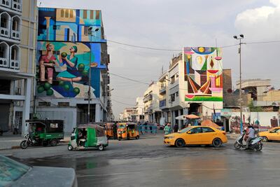Murals drawn by Iraqi painter Wijdan Al Majed in Baghdad. On the left is Hafidh Aldroubi's watermelon sellers and the right is Jewad Selim's painting. AFP