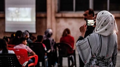 A woman uses a cell phone to capture the moment.