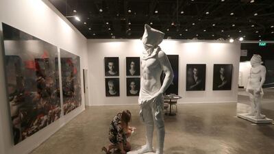 A worker adjusts a statue at the Art Dubai exhibition. Karim Sahib / AFP