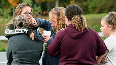 Friends of victims who died in fatal limousine crash comfort each other after placing flowers at the junction in Schoharie, New York. AP Photo