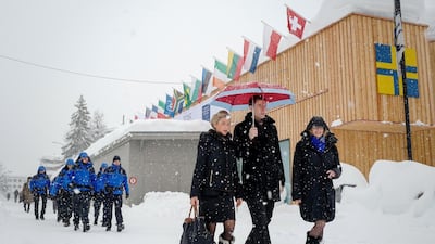 People walk through the resort town of Davos as snow falls ahead of the World Economic Forum's 2018 annual meeting in Switzerland. Photo by AFP