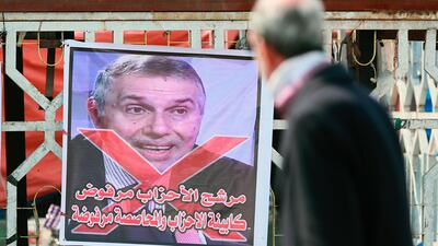 A poster of Iraq's Prime Minister designate Mohammed Allawi with Arabic that reads, "The party candidate is rejected" is seen during ongoing anti-government protests in Tahrir Square, Baghdad, Iraq, Saturday, Feb. 29, 2020. AP