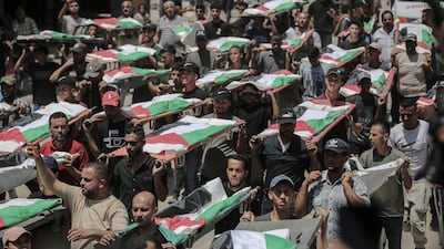 Palestinians at the mass burial of members of the Abu Sharia and Al Hasayna families whose bodies were recently found beneath Gaza buildings struck by Israel. Bloomberg