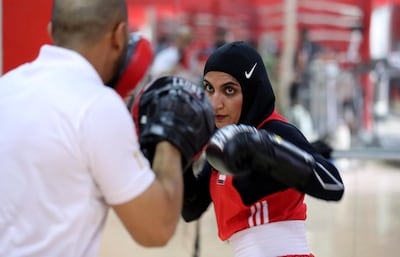 Fahima Falaknaz hits the pads with UAE national team coach Mohammed Al Shebli. Pawan Singh / The National