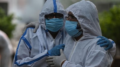 Relatives wearing Personal Protective Equipment arrive for the funeral of their relative who died due to Covid 19 coronavirus, at a crematorium in New Delhi. AFP