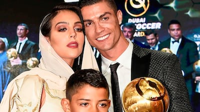 Juventus' Portuguese forward Cristiano Ronaldo (R), holding his "Best Player of the Year 2018 Award" poses his companion Georgina Rodriguez (L) and his son Cristiano Jr, holding his father's "433 Fans' Award", during the 10th edition of the Dubai Globe Soccer Awards in Dubai. AFP