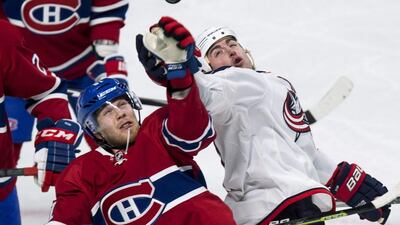 Montreal Canadiens’ Lars Eller, left, and Columbus Blue Jackets’ Brandon Dubinsky reach for a high-flying puck during the second period of an NHL hockey game on January 26, 2016, in Montreal. Paul Chiasson / The Canadian Press via AP