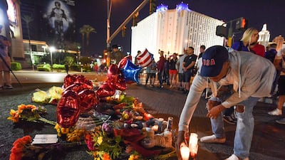 A man places a candle at a makeshift memorial near the Mandalay Bay hotel on the Las Vegas Strip on October 3, 2017, after a gunman killed 58 people and wounded more than 500 others. Robyn Beck / AFP