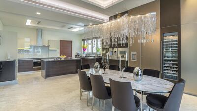 A dramatic chandelier adds some extra taste to meal times. Courtesy LuxuryProperty.com