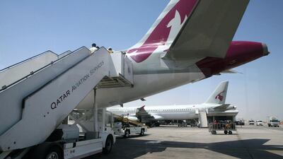 Passengers board a Qatar Airways plane at the Doha International Airport. Randi Sokoloff / The National