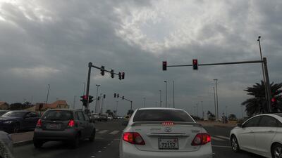 Bright red lights from cars and traffic signal lights add a little colour to an overcast sky in Abu Dhabi on Tuesday. Delores Johnson / The National