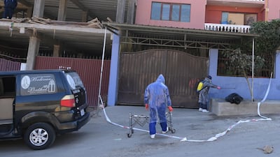 An employee of a funeral home disinfects a bag containing the body of a man who died on a street in Cochabamba, Bolivia. Reuters