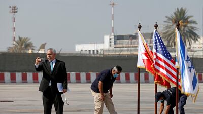 Israeli foreign ministry spokesman Lior Haiat holds a mobile phone as he speaks at Bahrain International Airport. Reuters