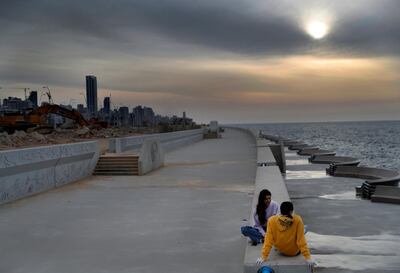 A couple sit on the side of an empty waterfront promenade in Beirut after a government order to stay home to stop the spread of the coronavirus. AP
